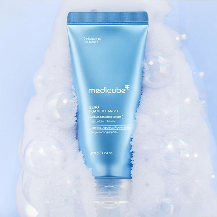 Medicube foam cleanser bottle with bubbles & foam on a blue background