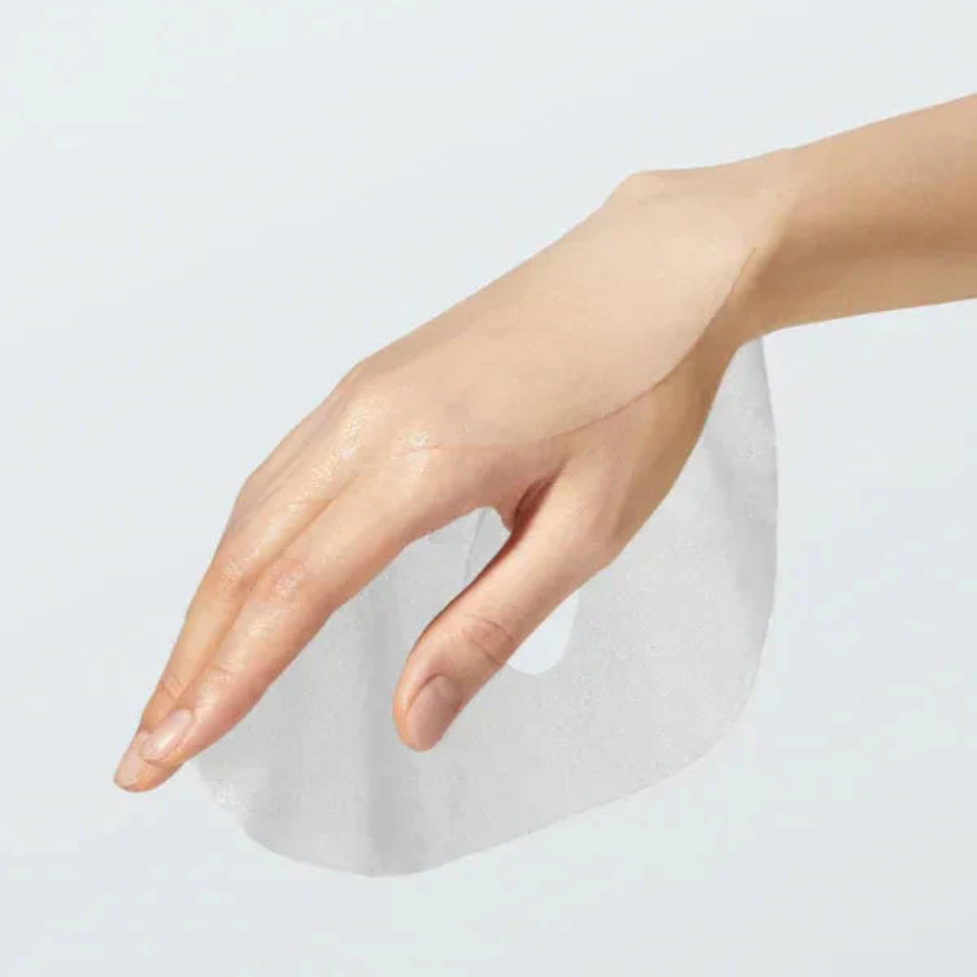 Hand holding a mask against a light gray background