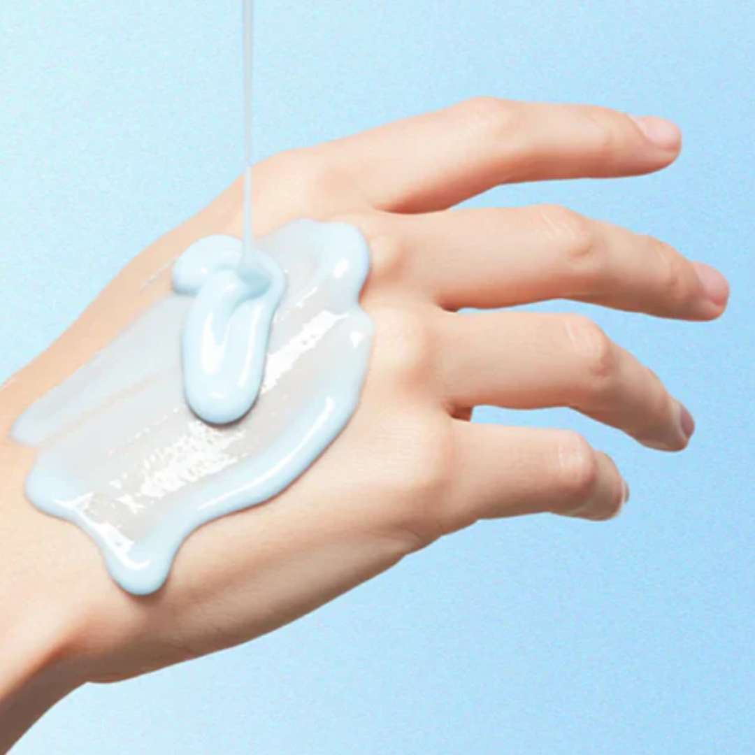 Hand with a small amount of light blue gel-like substance on a light blue background