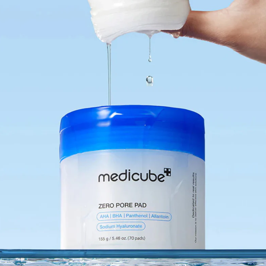 Medicube Zero Pore Pad container with a hand pouring liquid onto it against a blue background