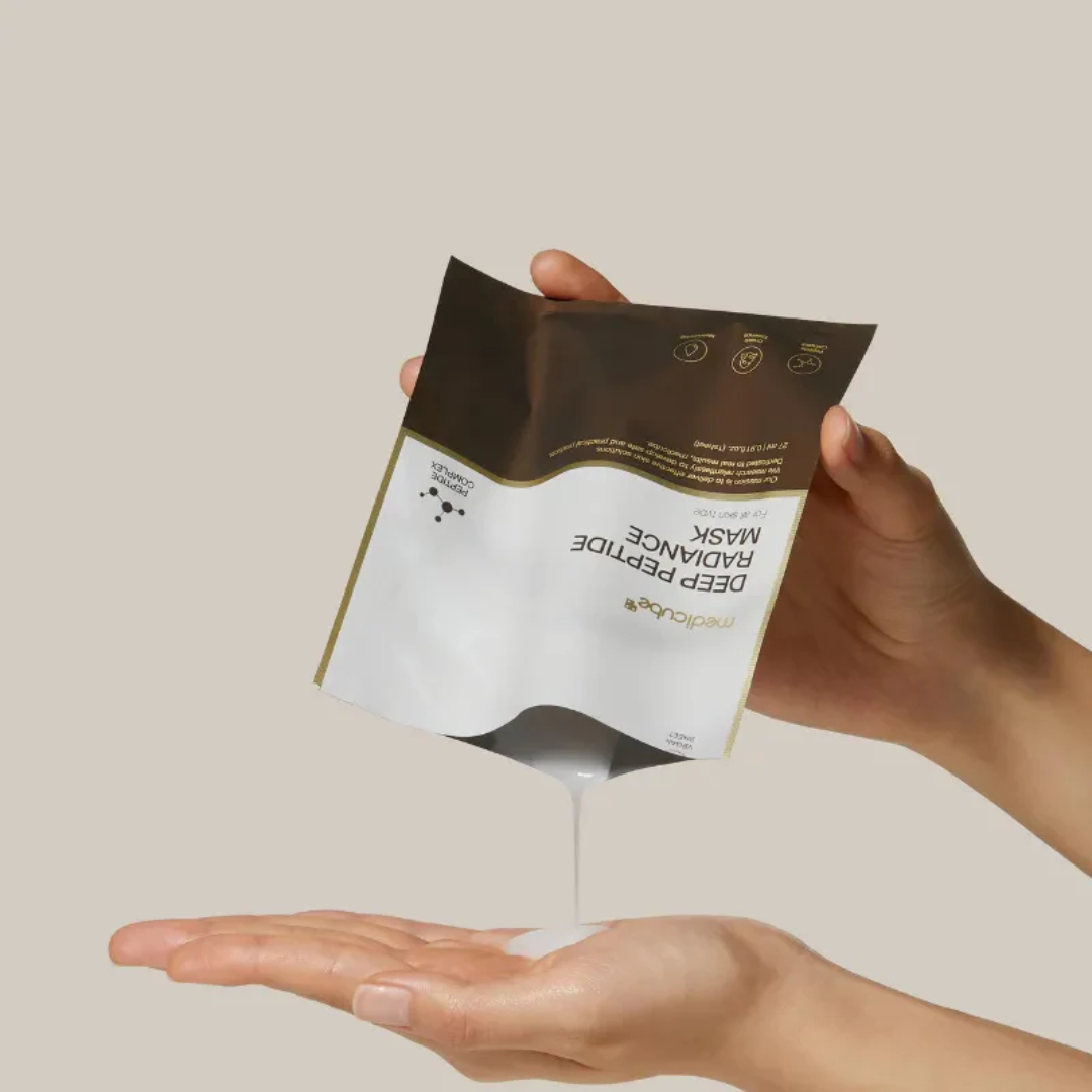 Person holding a skincare mask package against a neutral background