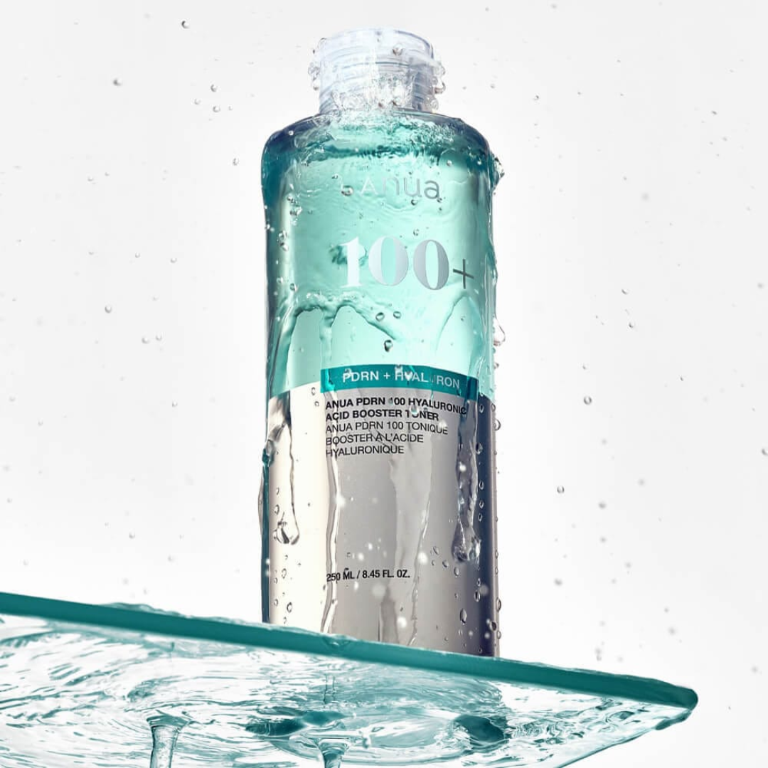Skincare bottle with water droplets on a light gray background