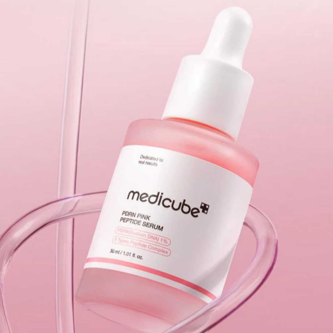Medicube pink peptide serum bottle with dropper on a pink background