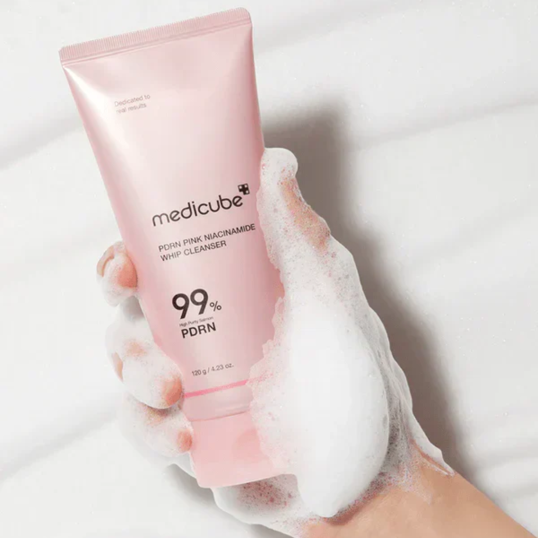 Pink tube of Medicube cleanser with foam on a white background