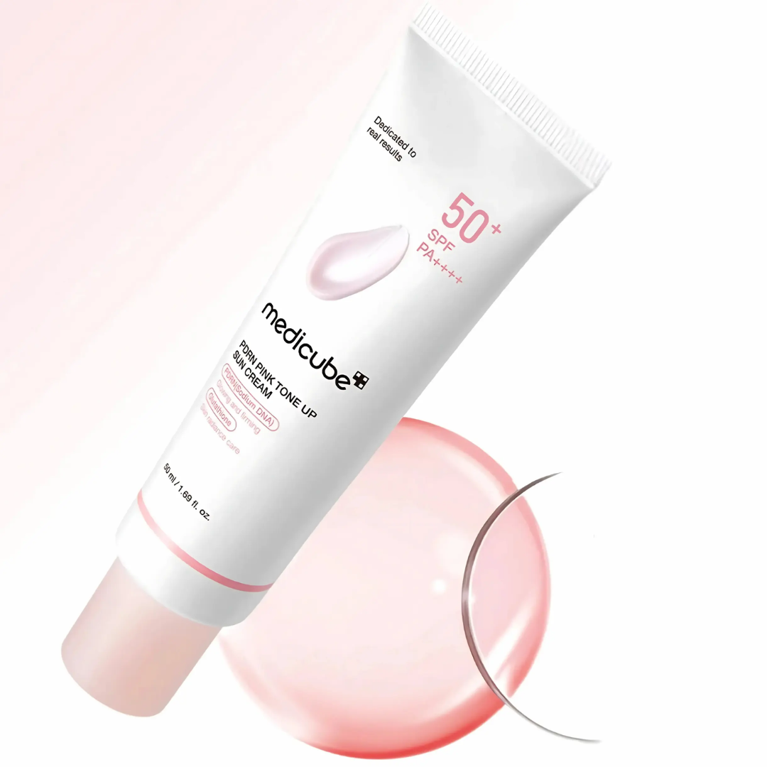 Medicube sunscreen cream tube with pink applicator on a white background