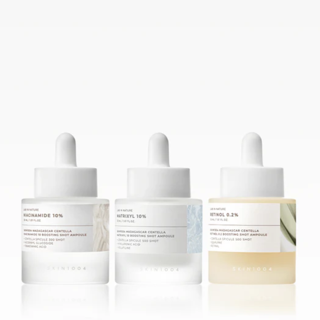 Three skincare ampoules with droppers on a white background