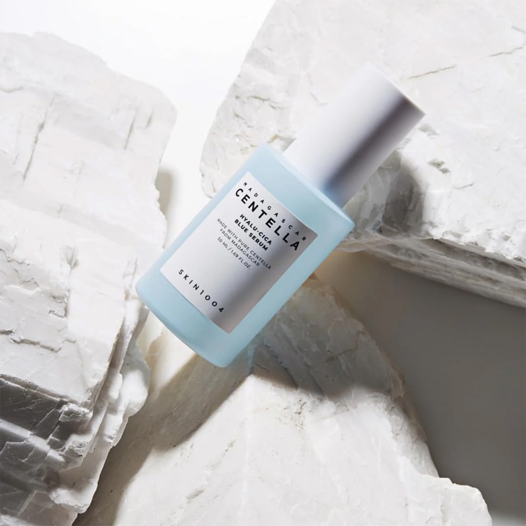Skincare bottle with blue label on a textured white background