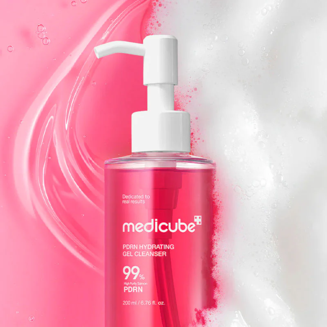 Pink bottle of Medicube gel cleanser with white pump on a gel and foam background