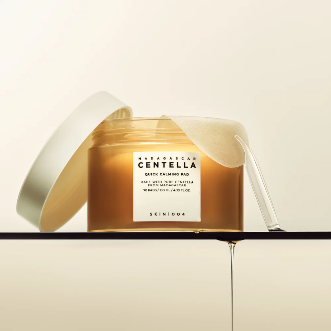 Skincare product with a gold container and white label on a beige background