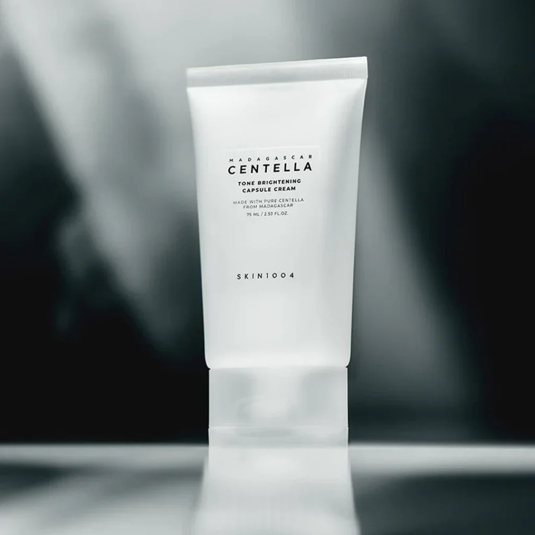 Skincare tube with 'SKIN1004' branding on a blurred background