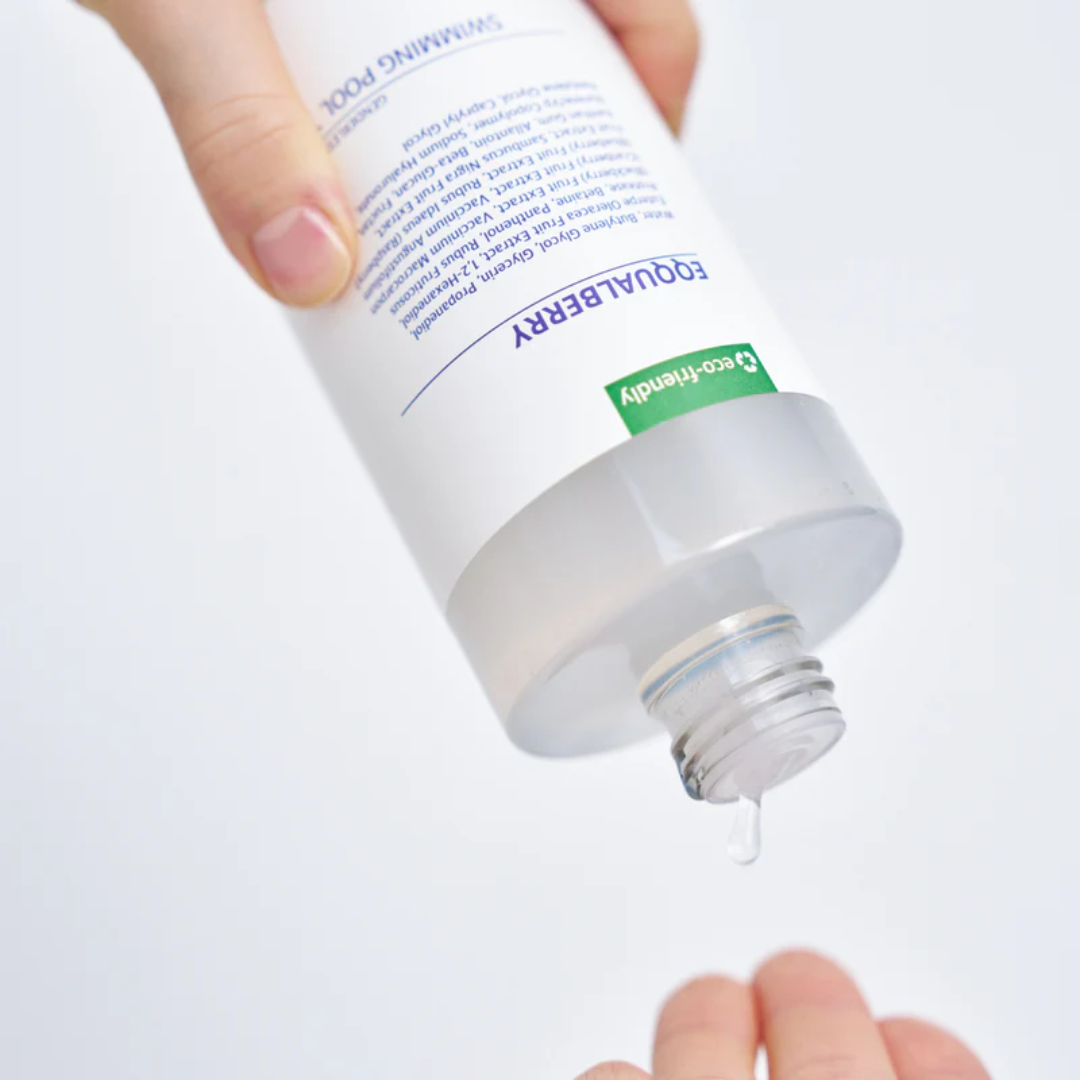 Hand holding a tube of Equaliberry cream with a white background