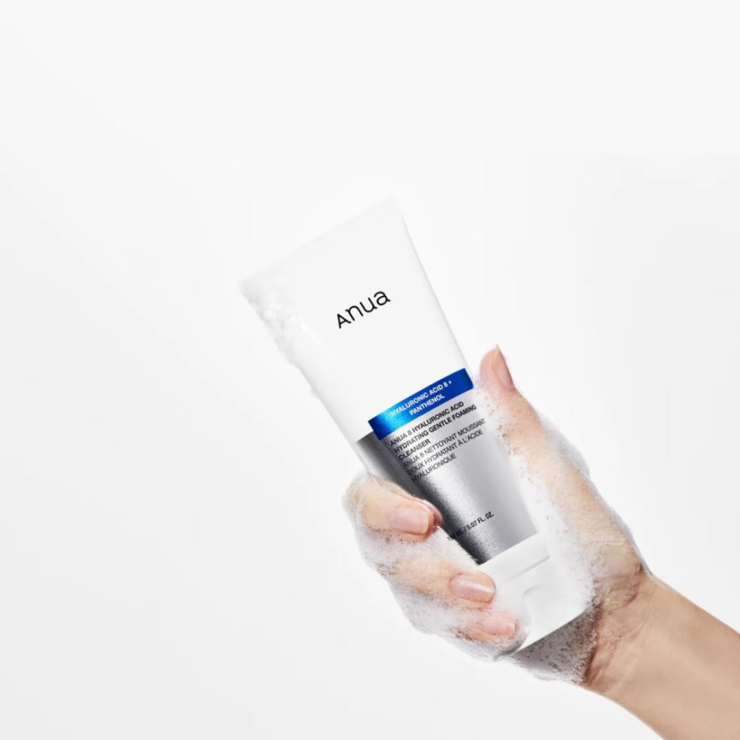 Hand holding a skincare product with 'anua' branding on a white background