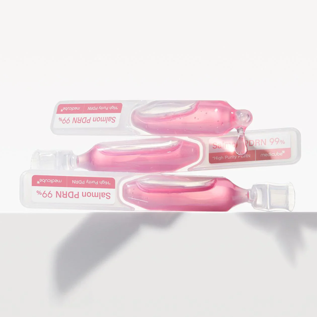 Three pink dental floss containers with visible brand names on a white background