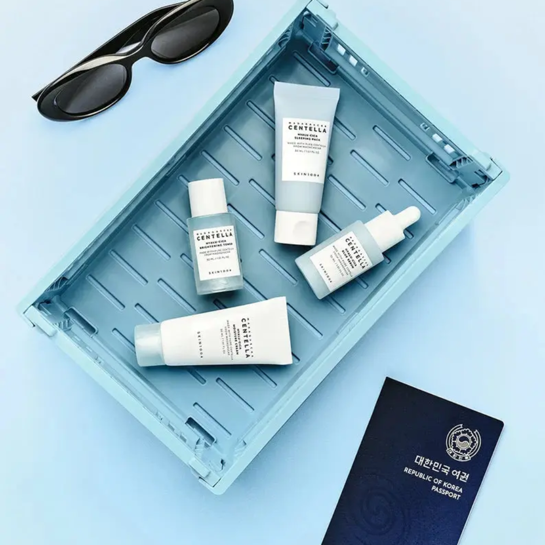 Cosmetic products and sunglasses on a blue tray with a passport on a light blue background