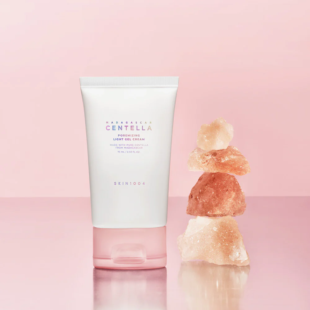 Skincare product with a stack of stones on a pink background