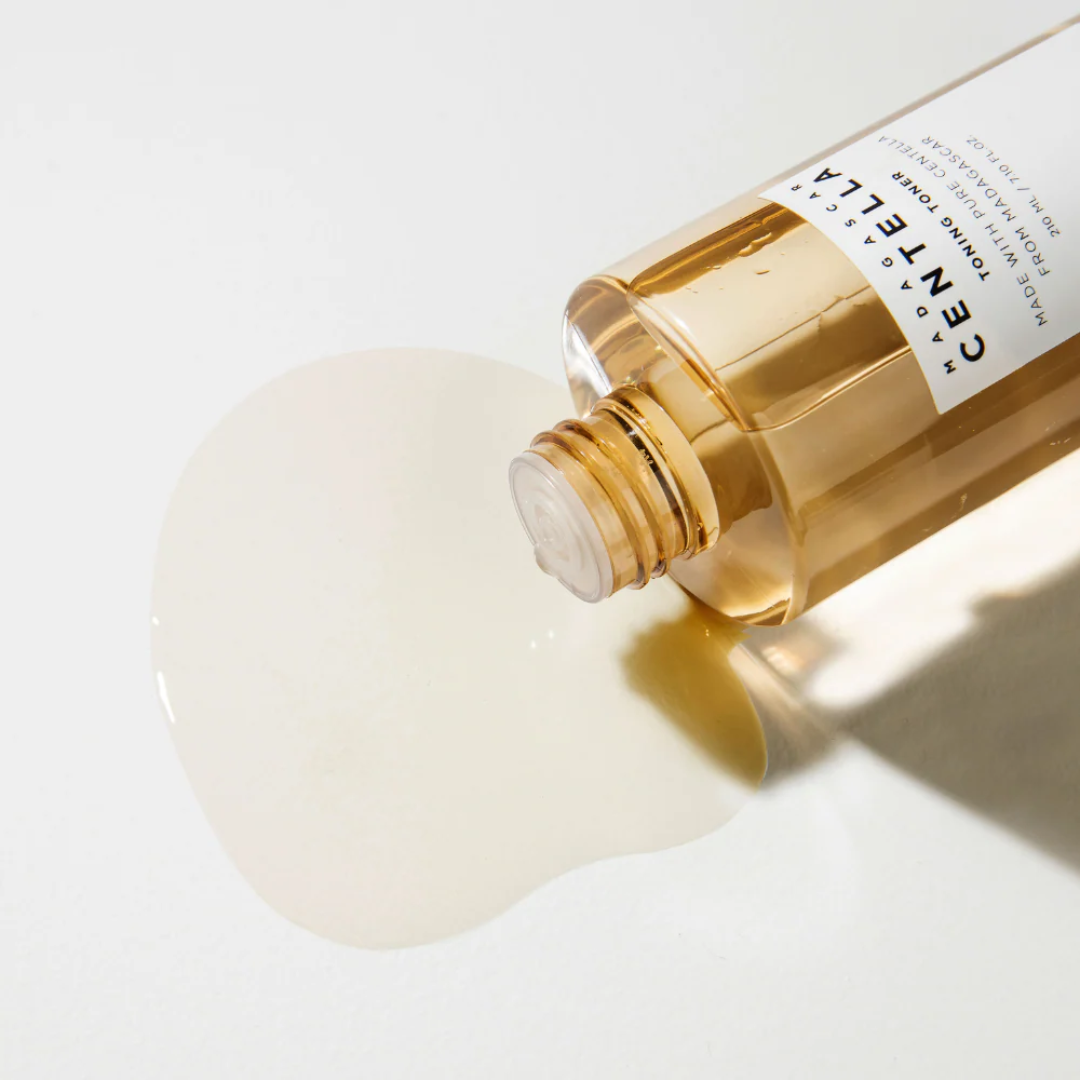 Skincare bottle with droplet on a light background