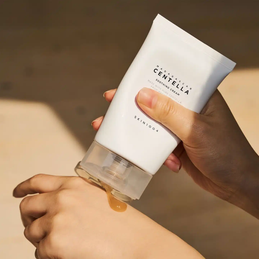 Hand applying skincare cream to wrist with visible brand name