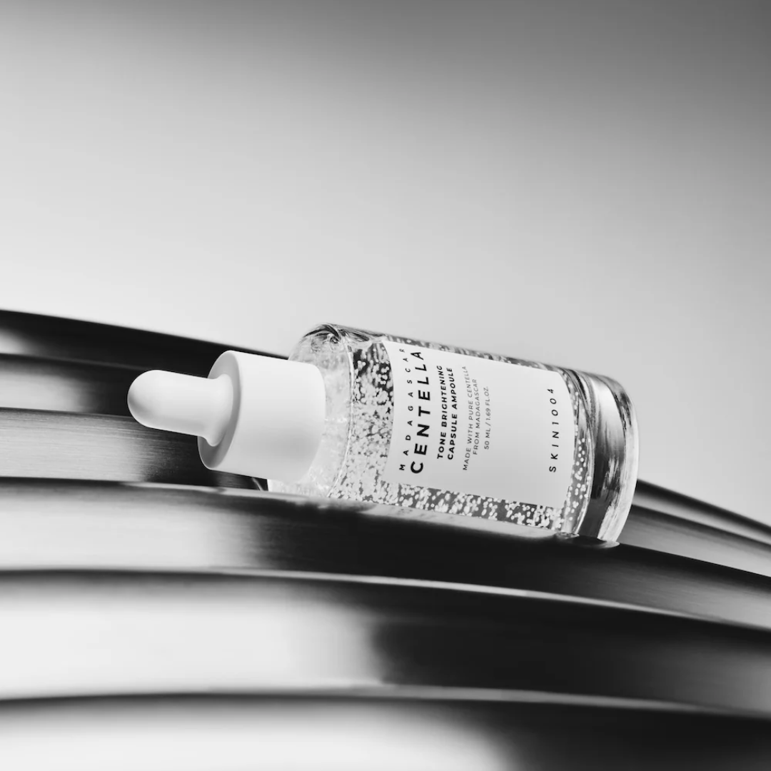 Skincare dropper bottle with a label on a reflective surface