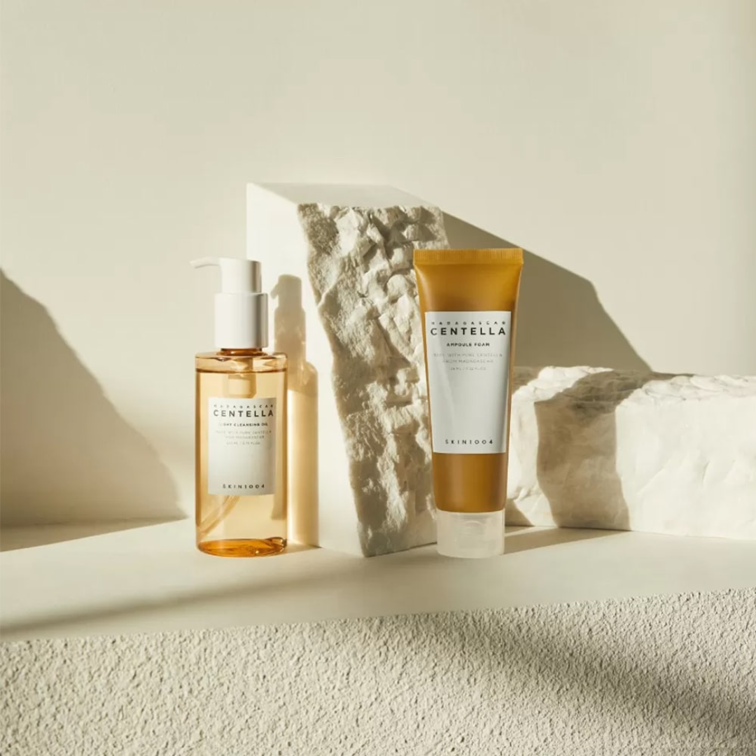 Two skincare products on a textured surface with a neutral background