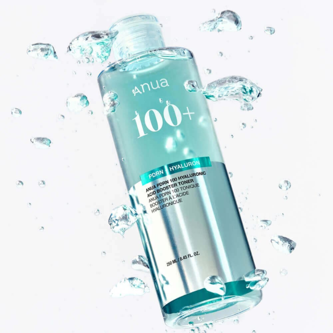 Anua 100+ toner bottle with water droplets on a white background