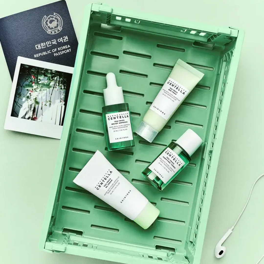 Cosmetic products on a green tray with a passport and photo album in the background.