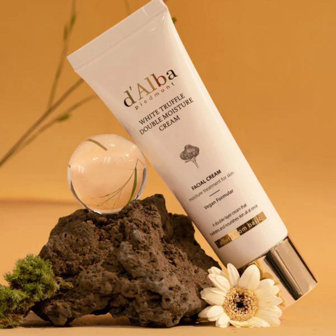 Tube of d'Alba White Truffle Double Moisture Cream on a textured surface with decorative elements.