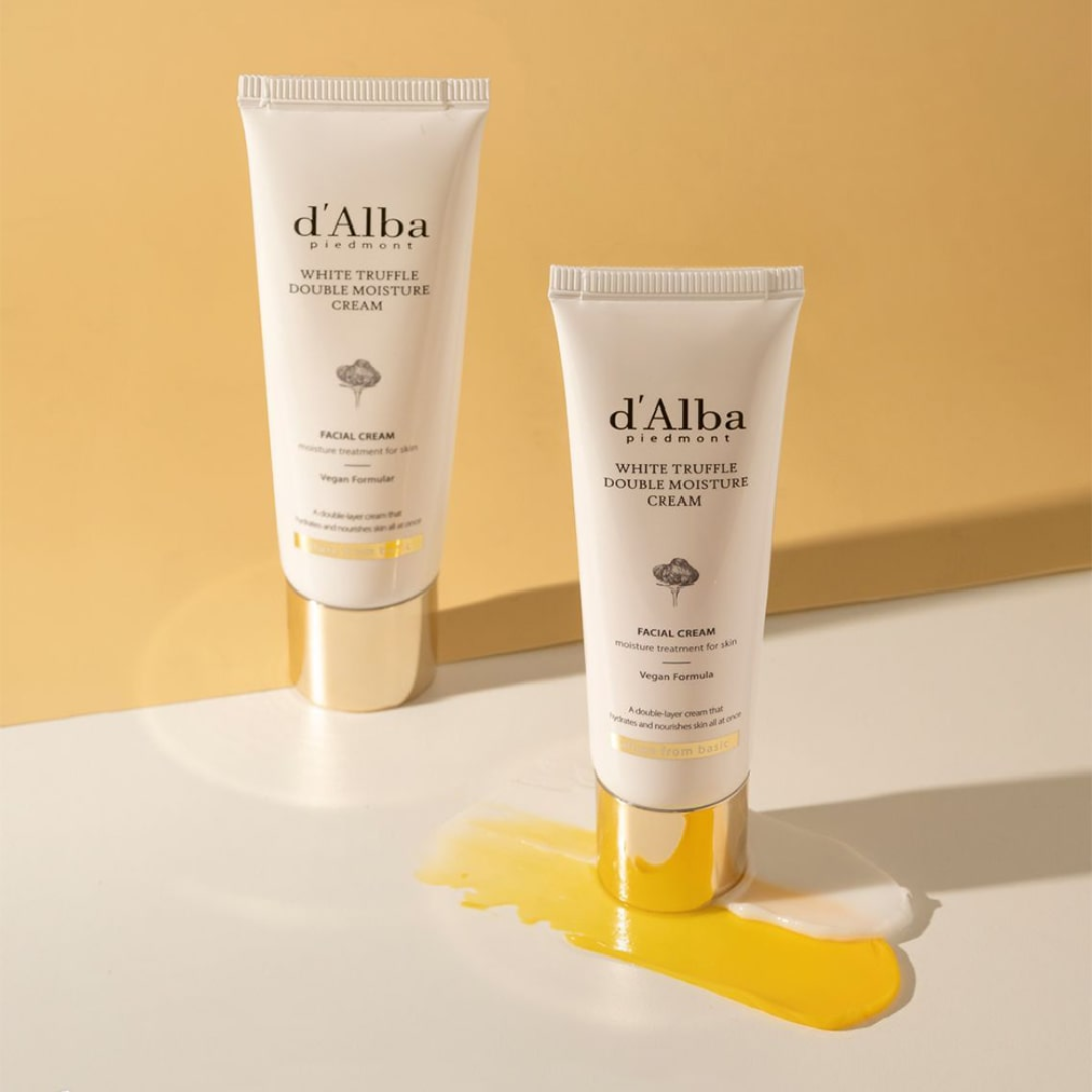 Two tubes of d'Alba White Truffle Double Moisture Cream on a light surface with a yellow background