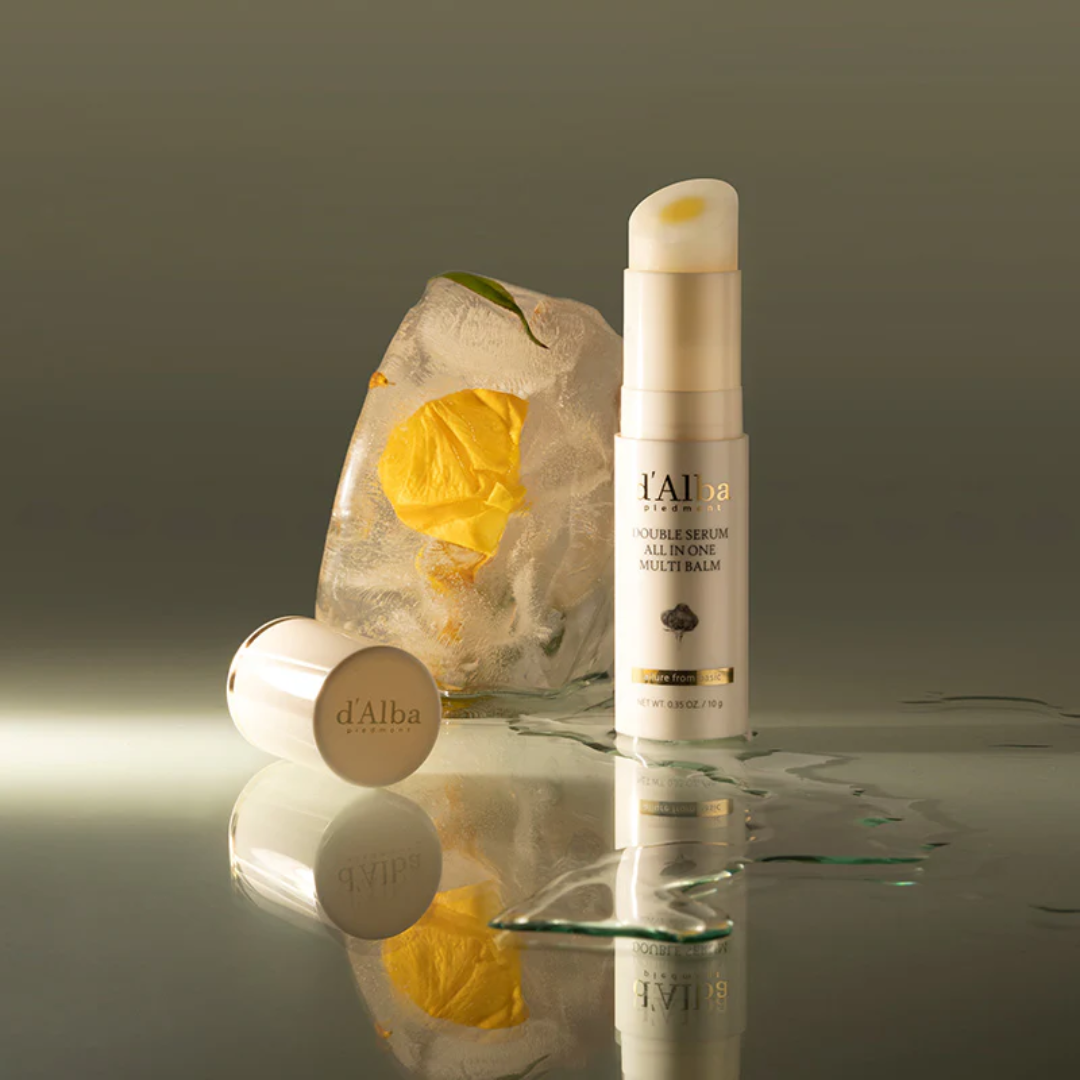 Skincare products with a yellow flower on ice, branded 'd'Alba', on a reflective surface.