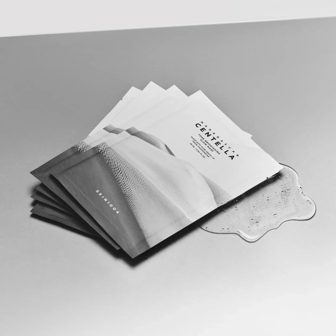 Sheet masks with branding on a gray surface