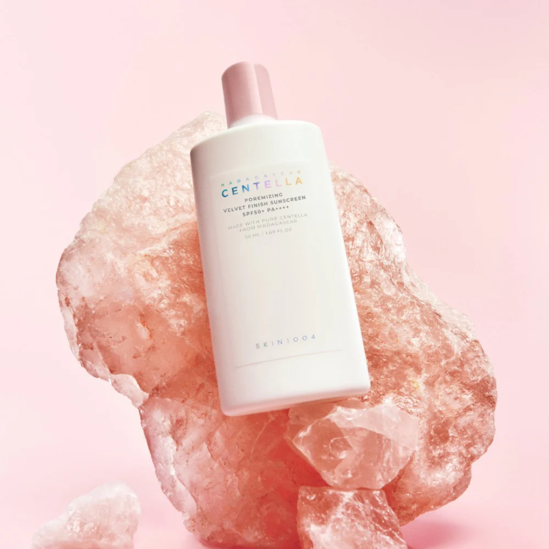Skincare bottle on a pink stone with a soft pink background