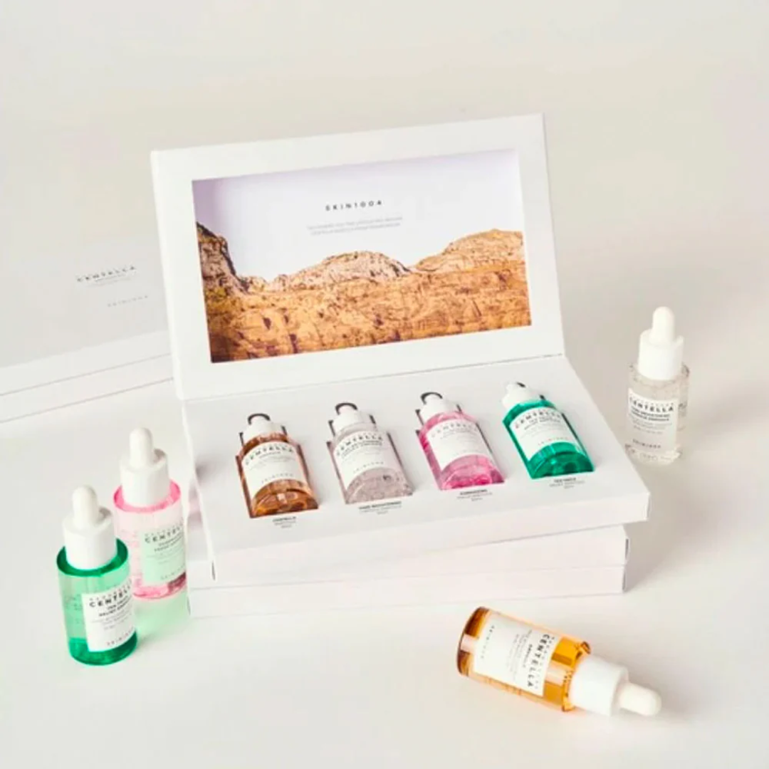 Set of skincare products including bottles and a dropper with a branded box on a light background