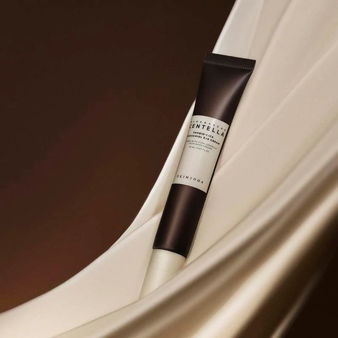 Skincare serum tube with a white and brown design on a draped fabric background