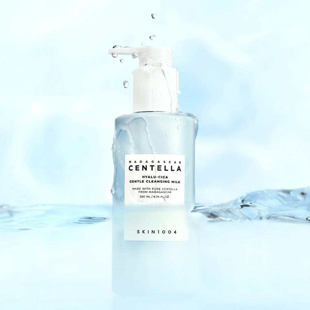 Bottle of Skin1004 Madagascan Centella Cleansing Milk with water droplets on a light blue background