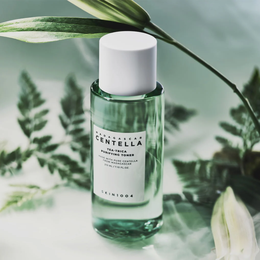 Skincare bottle with green liquid and white cap on a blurred natural background