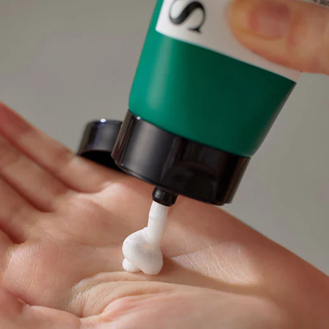 Green and white pump dispenser being used on a hand