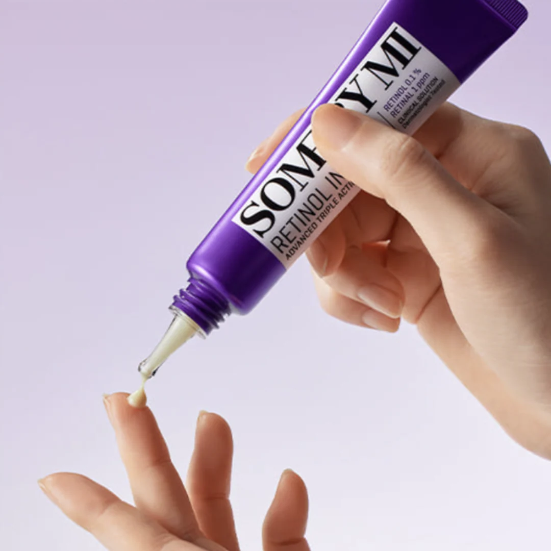 Hand holding a purple bottle labeled 'Sormi' with a dropper, against a light purple background.