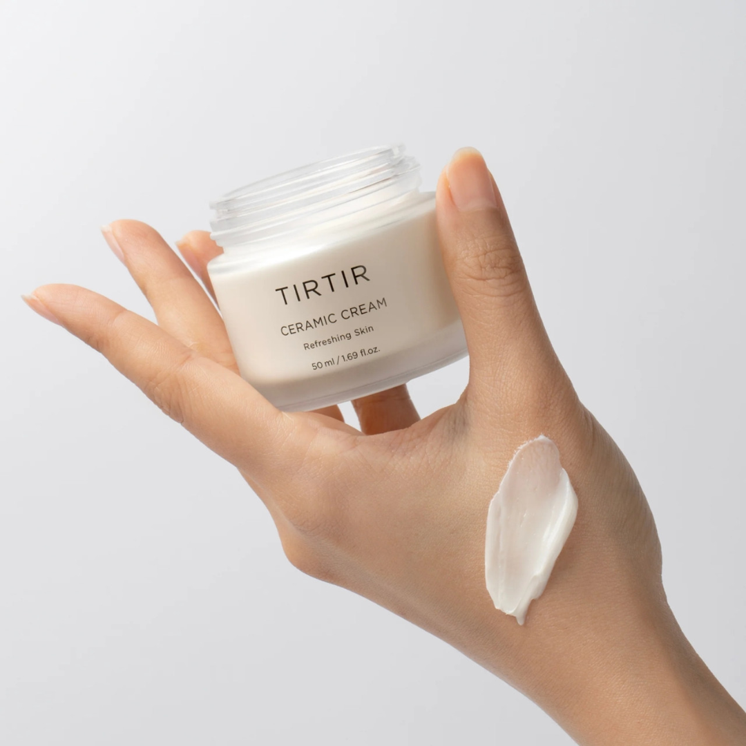 Hand holding a jar of Turtur cream against a light background