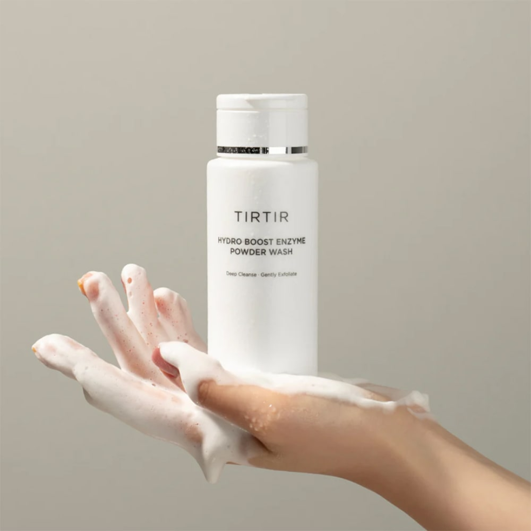 TIRTIR Hydro Boost Enzyme Powder Wash bottle with a hand holding the product on a neutral background