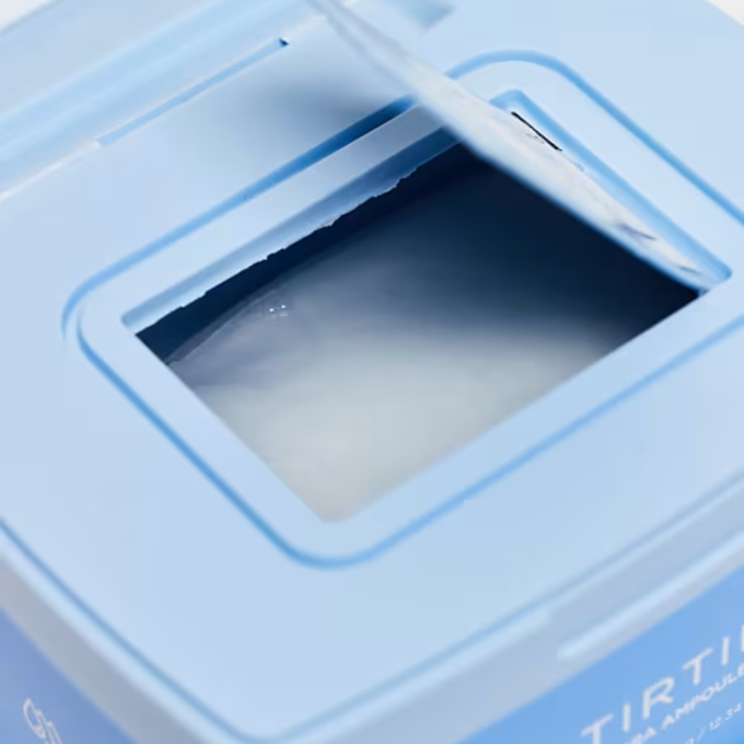 Close-up of a blue container with a clear lid, possibly containing a skincare product.