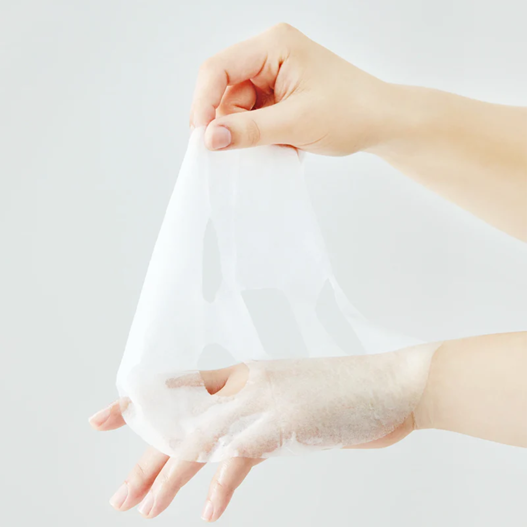 Hand holding a white sheet of paper against a light gray background