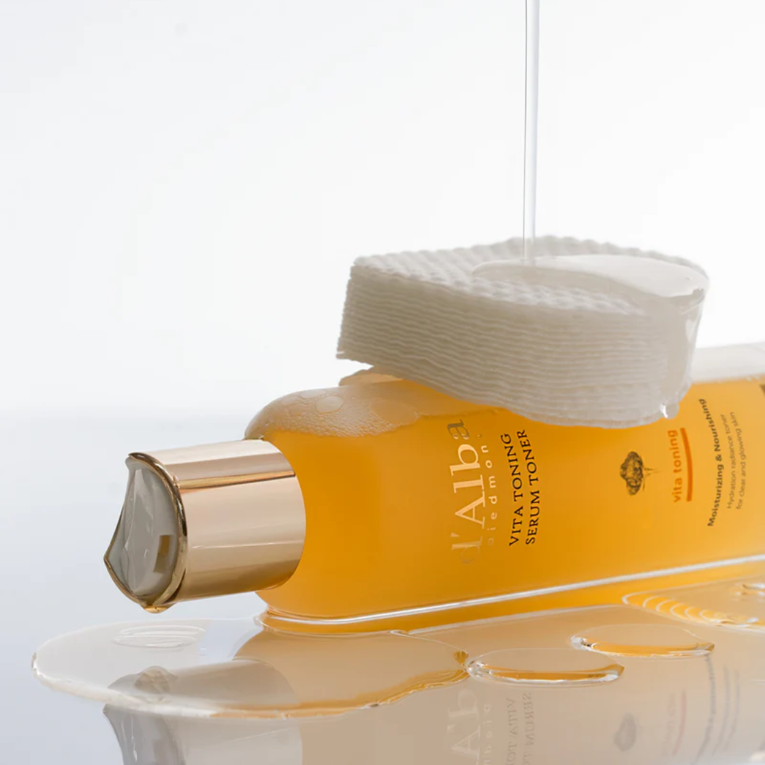 Yellow bottle with gold cap and white packaging on a light gray background