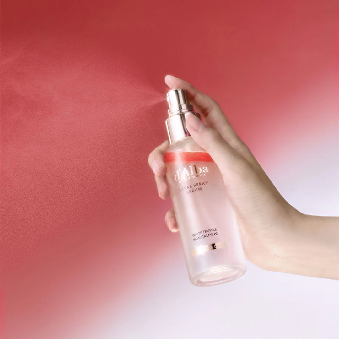 Hand holding a skincare serum bottle with a red background