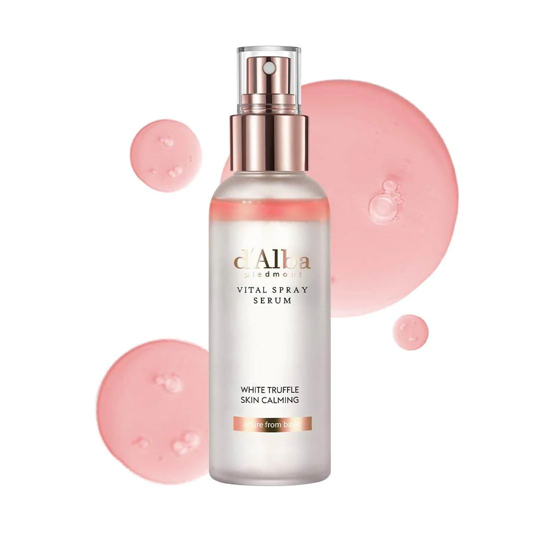 Spray serum bottle with pink droplets on a white background